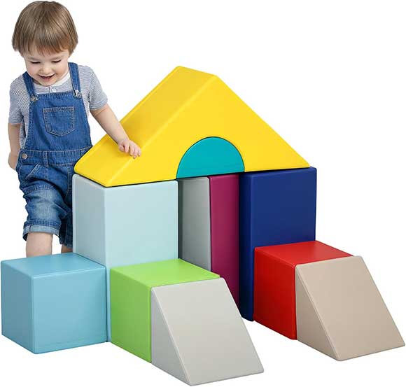Bambino che gioca con grandi costruzioni morbide in schiuma